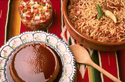 FOD351FM 002 001-Foods for a Mexican fiesta: enchilada casserole, salsa & flan on colorful tablecloth